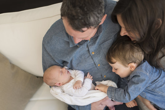 Elevated view of family looking at baby boy sleeping at home