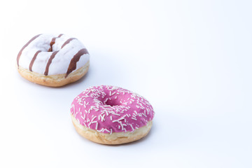 Two delicious donuts, a pink and a stripped white and brown isolated on white background