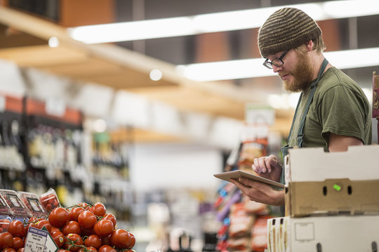 Worker using tablet computer at supermarket