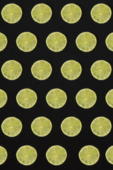 Lime pattern on black background. Minimal flat lay concept.