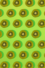 Pattern of kiwi. Top view of the sliced kiwi on green background. Minimal flat lay concept.