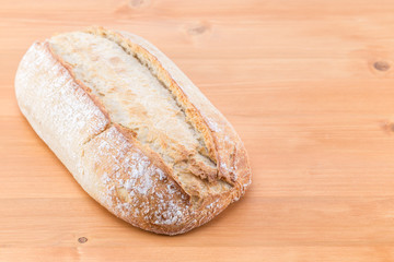 Loaf of homemade bread on an oak natural wood table