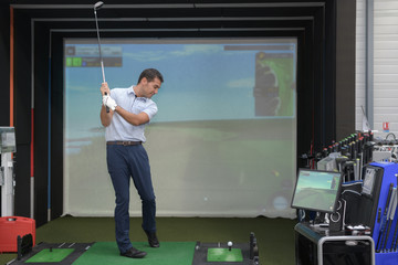 young man playing golf and interacting with a video-game