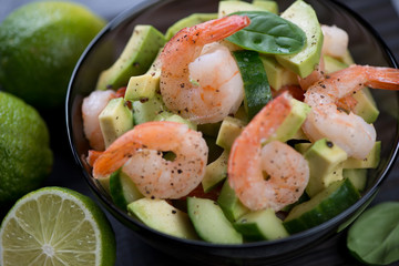 Close-up of avocado salad with tiger shrimps and cucumber, studio shot