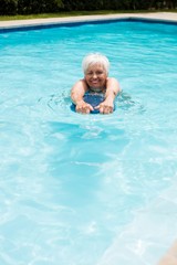 Fototapeta na wymiar Senior woman swimming in the pool