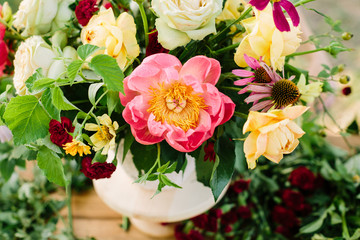 floral design, decoration, applied art, wedding, spring concept - flower bouquet arranged of blooming english roses and avalanches, coral peonies and diathuses, decorated with raspberry leaves