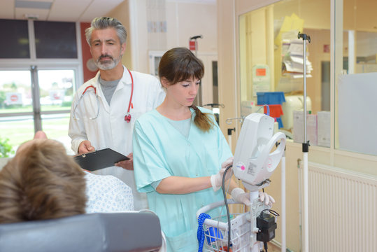 doctor and nurse interacting with patient in hospital room