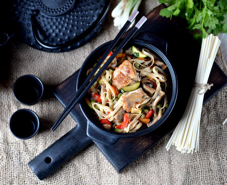 Udon noodles with chicken, pepper, carrots, onions, zucchini and mushrooms in teriyaki sauce. Asian cuisine.