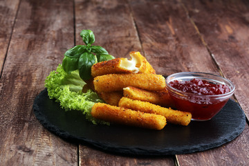Breaded mozzarella cheese sticks with tomato ketchup and bbq sauce