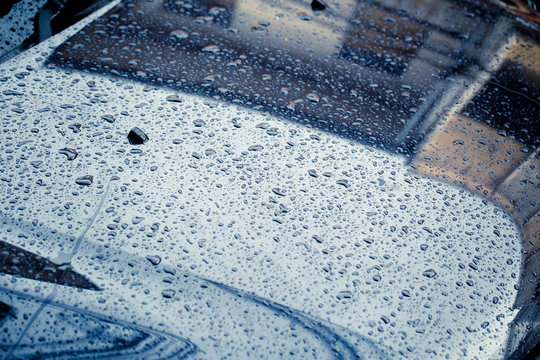 Car Hood with rain drop wet clean dark storm color tone in raining season.
