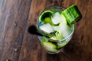 Cucumber Cocktail with vodka and tonic on dark wooden surface.