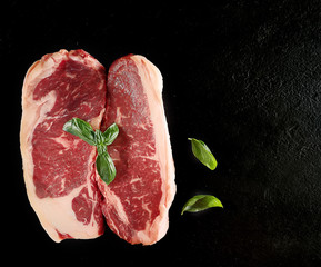 raw beef steak marble on a black background.top view