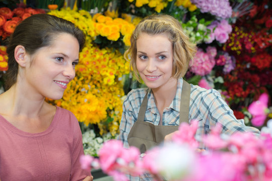 cheerful florist advising her female customer