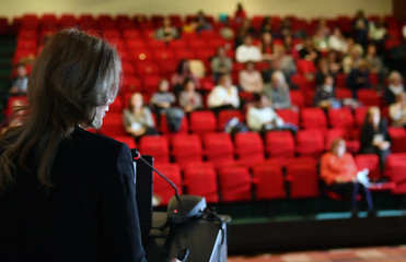 Speaker at a conference in front of auditorium