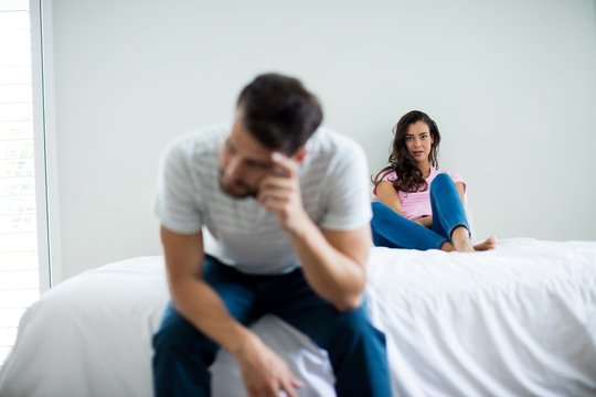 Couple ignoring each other in bedroom