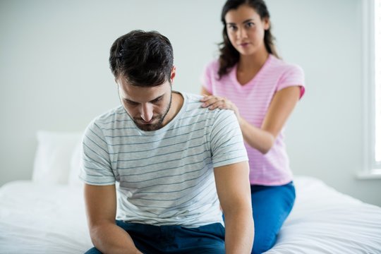 Upset couple sitting on bed in the bedroom