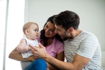 Parents playing with their baby girl in bedroom