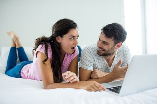 Couple using laptop in the bedroom