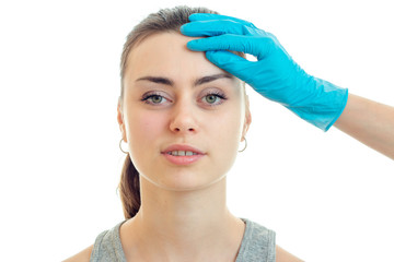 Portrait of a charming young girl without makeup at the doctor in blue gloves