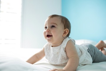 Fototapeta premium Cute smiling baby girl on bed
