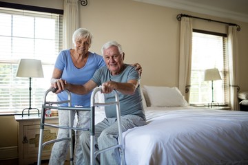 Senior woman helping man to walk with a walker