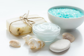 Fototapeta na wymiar blue sea salt, soap and body cream on white desk background
