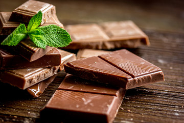black chocolate design with mint on wooden background