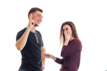 cheerful young couple standing near each other laugh and show hands gestures
