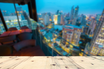 Fototapeta na wymiar Rooftop wood floor, with cityscape view of Bangkok city in evening