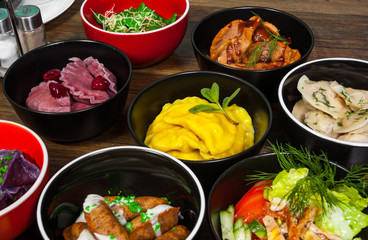 Set of different dumplings and ravioli on a wooden table