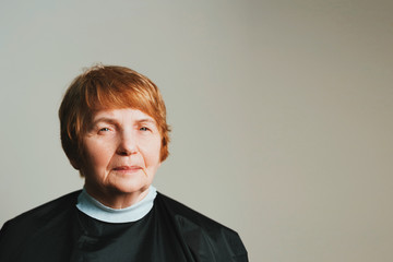 Portrait of beautiful old woman in peignoir after haircut