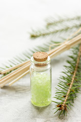 Spruce spa with organic salt in bottles on white table background