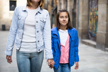 Mother and daughter taking walk in city