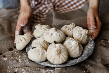 National Georgian cuisine Khinkali. Senior woman prepares khinkali. Top view raw meat dough dish uncooked. Process cooking.