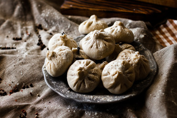 traditional Georgian dish khinkali on a plate on a dark background.