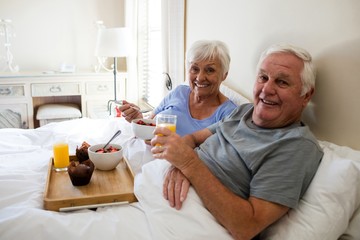 Portrait of senior couple having breakfast in the bedroom