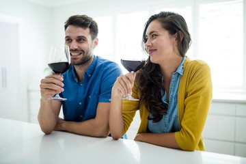 Couple having red wine in the kitchen