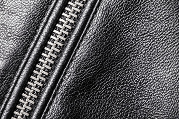 Metal zipper fully zipped on black leather jacket macro pattern.