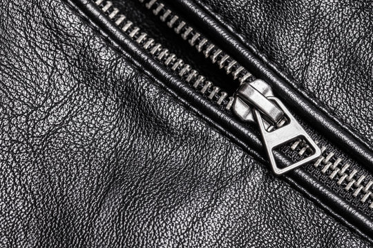 Shiny metal silver zipper. Black leather jacket fashion background.