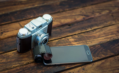 Vintage camera next to a cell phone