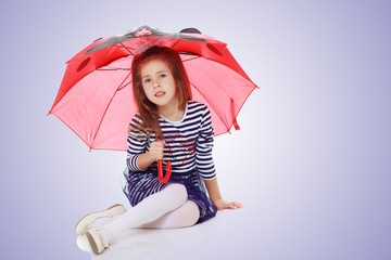 Little girl hiding under an umbrella.