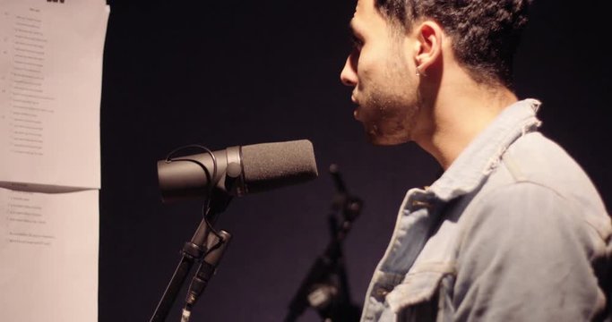 Slow motion of singer recording vocals at recording studio