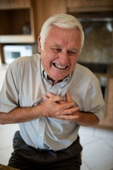Senior man suffering from heart attack in the kitchen