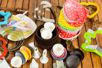 Different baking accessories over wooden background