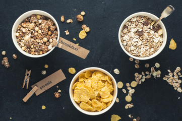 Breakfast cereals in paper cups over dark concrete background. Diet or healthy eating concept