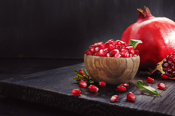 Ripe pomegranate seeds  on black wooden vintage background