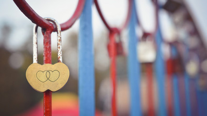 Old rusted heart-shaped padlock with two hearts engraved on it on the bridge. Valentine's day...