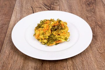 Vegetarian food on a plate with wooden background