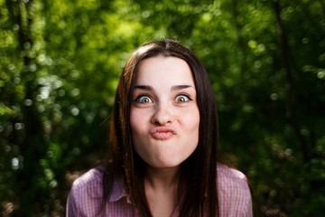 Fototapeta premium Portrait of cute young woman blowing lips kiss, grimacing for fun