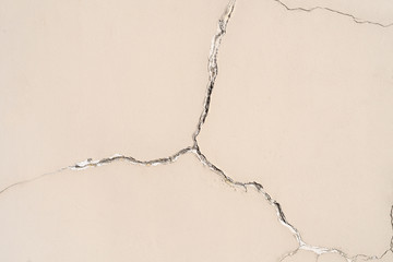 On the wall a large crack in the shape of a star on a beige plaster